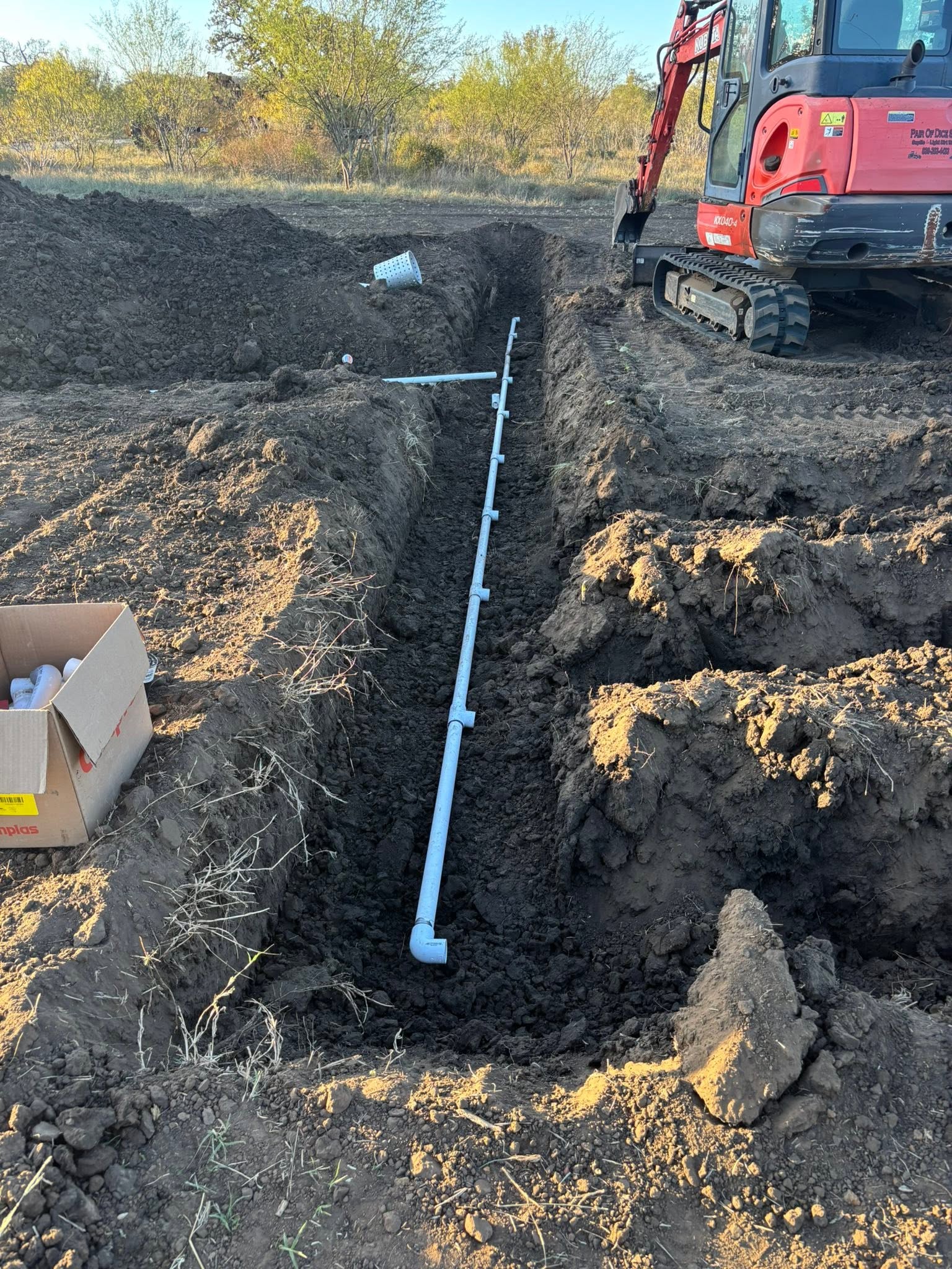 Compact excavator and newly installed pipe